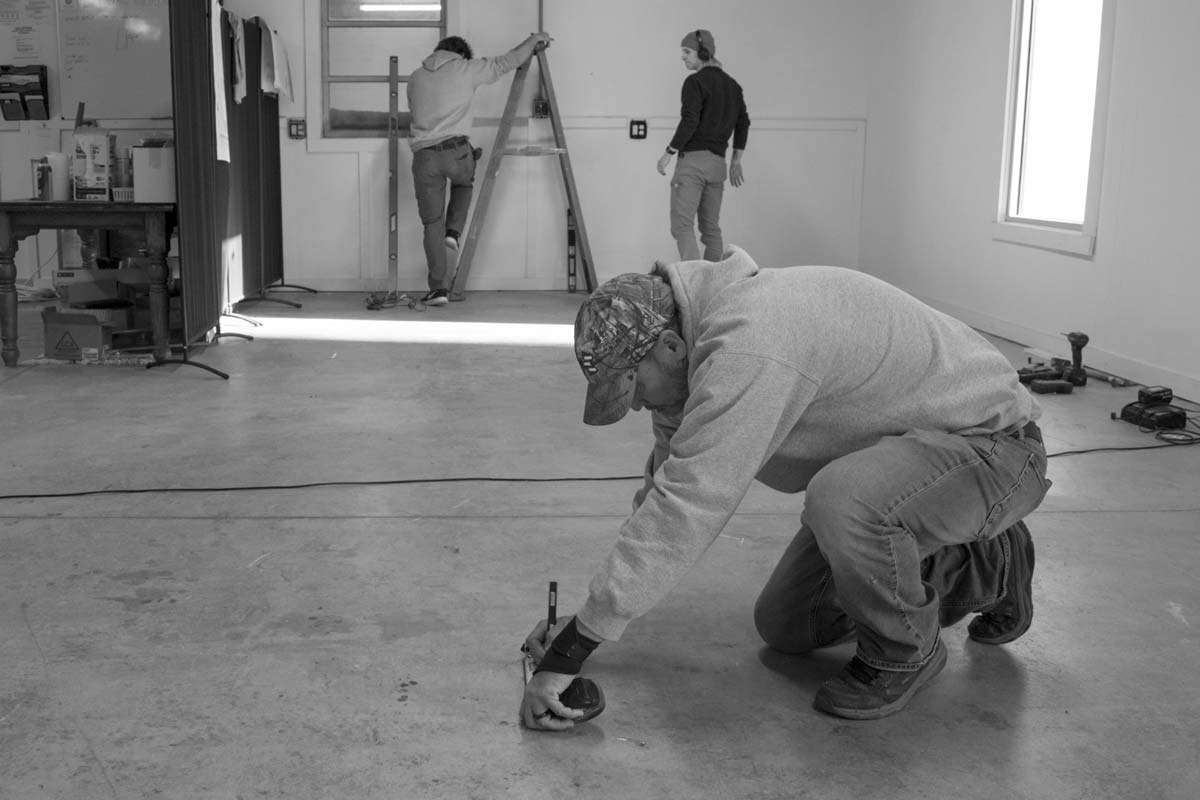 A construction professional take measurements in a commercial space.