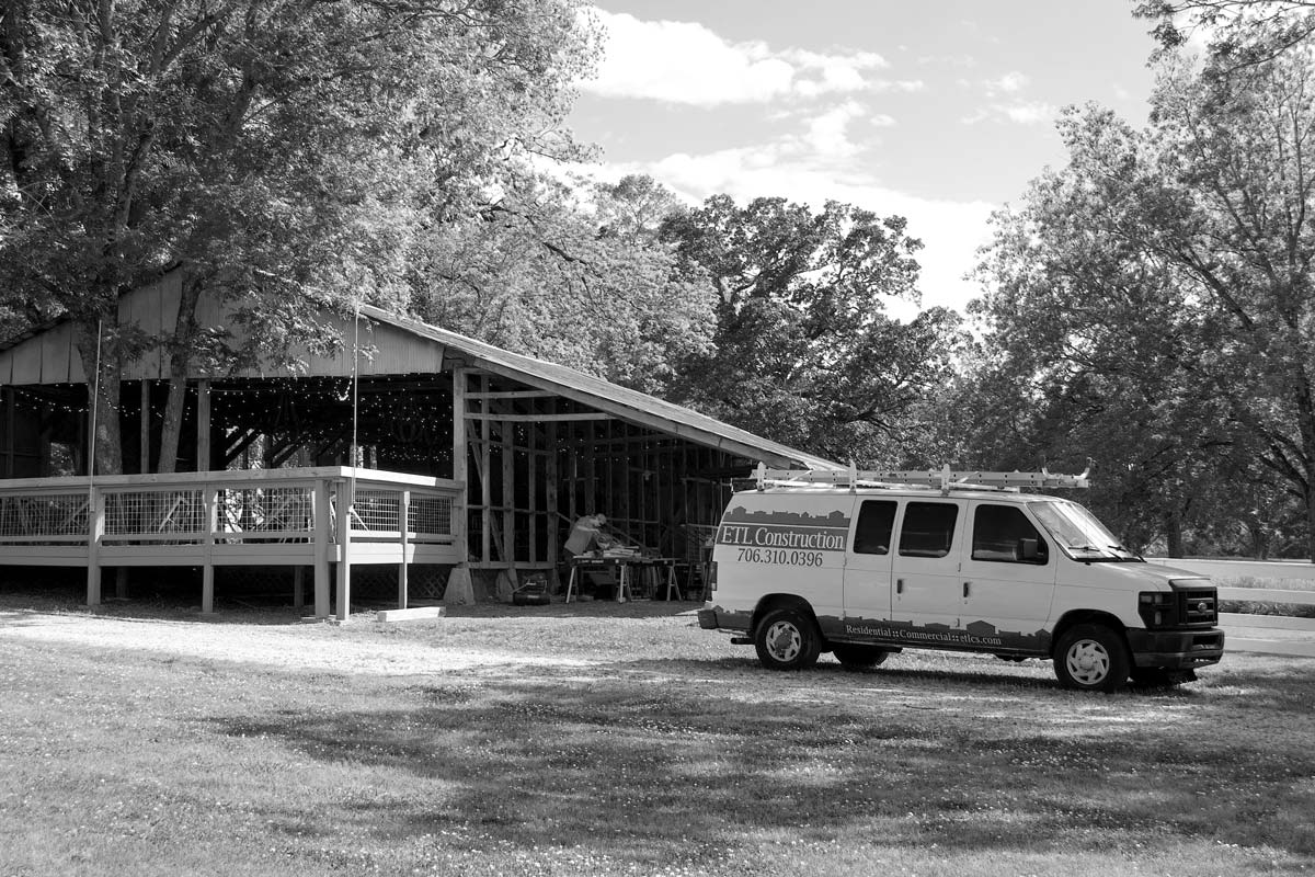 The ETL Construction Services van is parked next to an in-progress construction project.